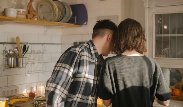 a couple in a kitchen with their back turned