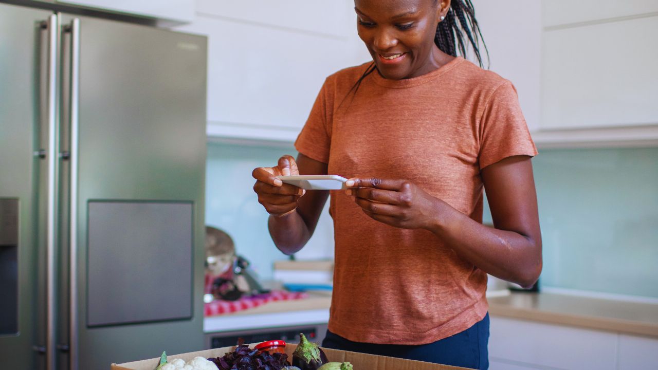 a woman photographic the ingredients in a ready meal delivery kit