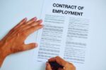 man signing an employment contract