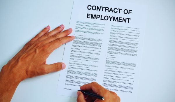 man signing an employment contract