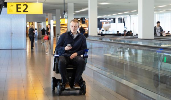 a man in a self-driving wheelchair at Schiphol airport