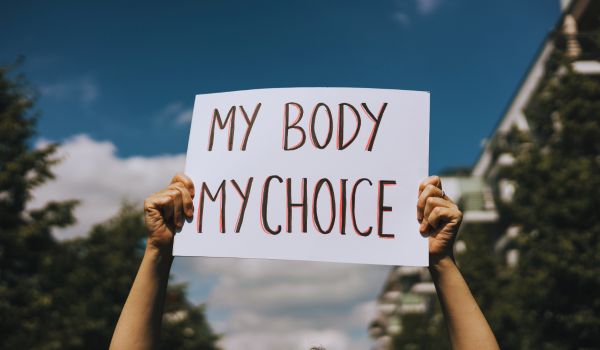 a woman holding a my body my choice sign