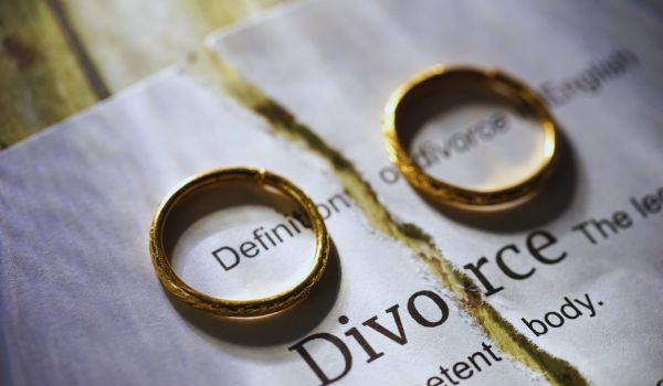 Two wedding rings set on a divorce contract