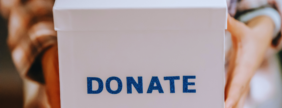 a person holding a donation box