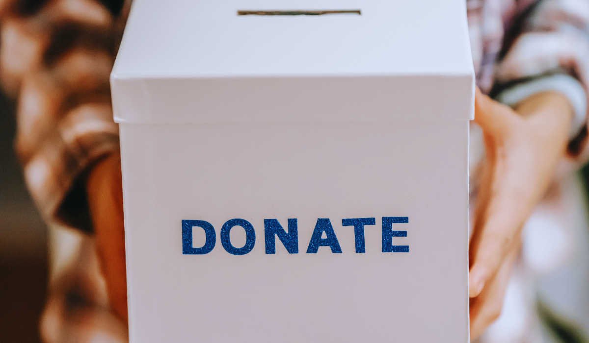 a person holding a donation box