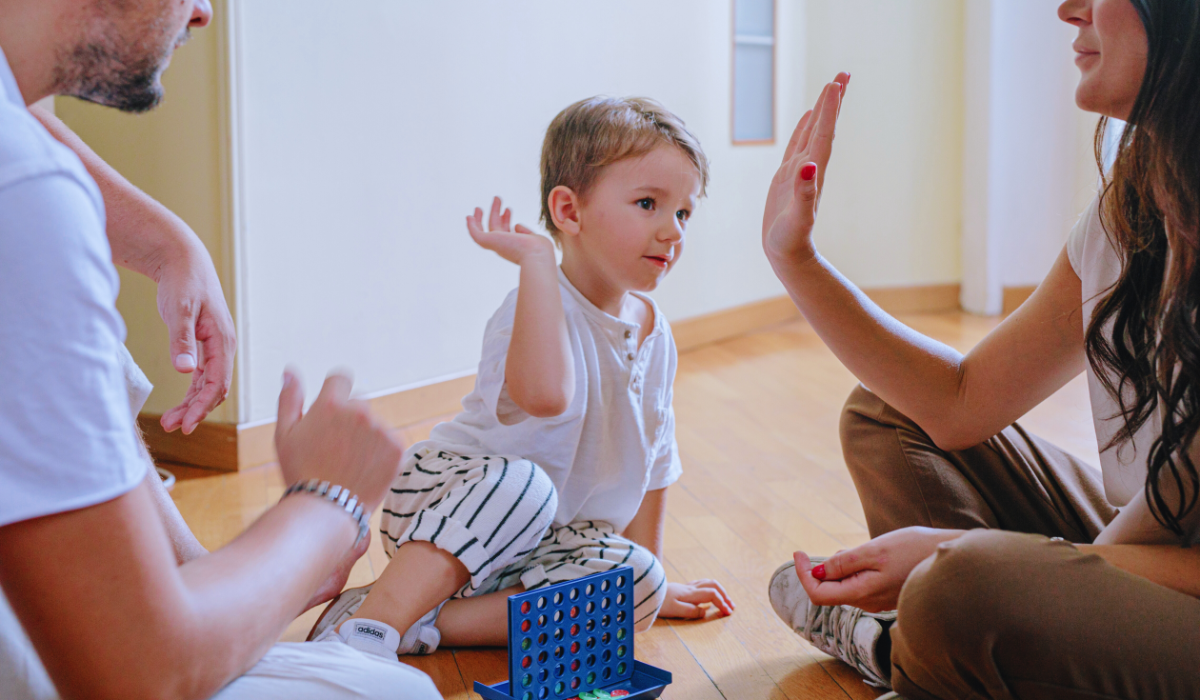 a happy child playing a game with his parents