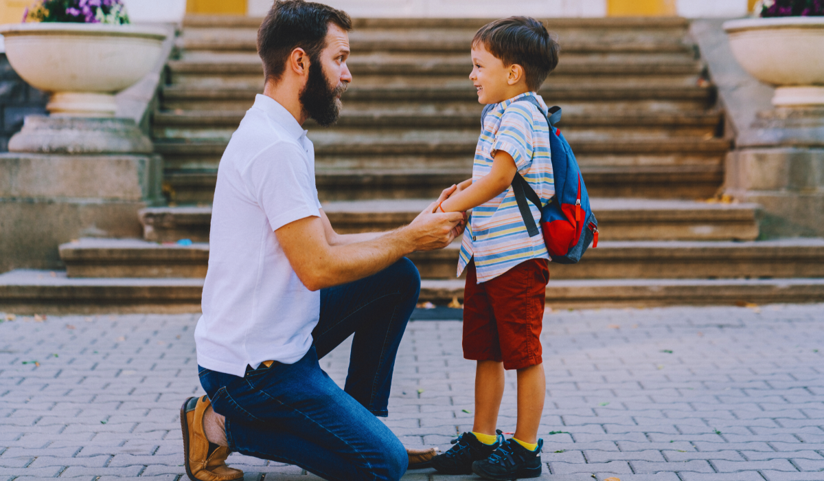 a father talking to his son on the first day of school