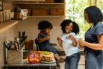 a mom and her two daughters laughing in the kitchen