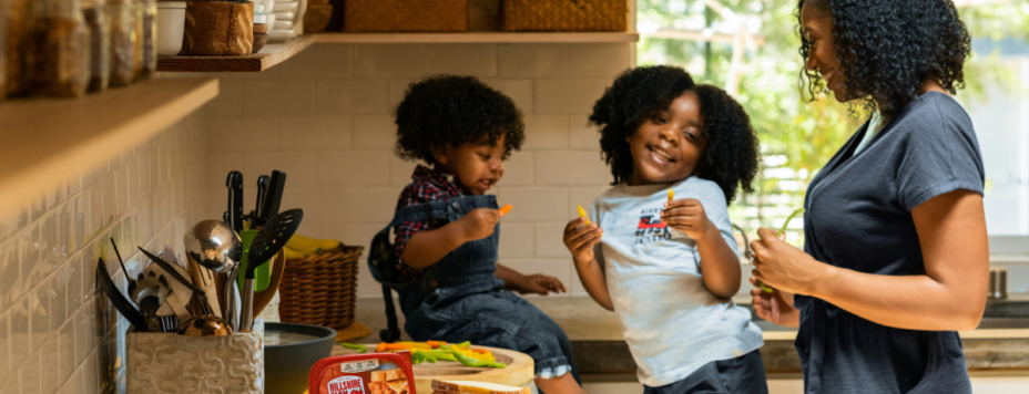 a mom and her two daughters laughing in the kitchen