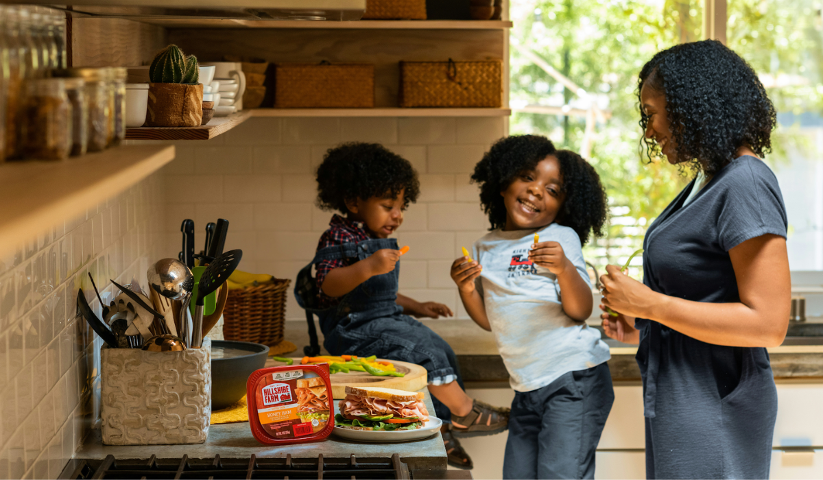 a mom and her two daughters laughing in the kitchen