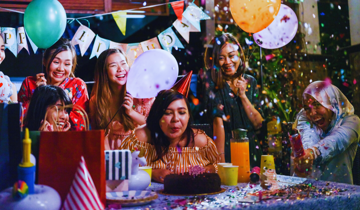 a woman blowing out the candles on her birthday cake