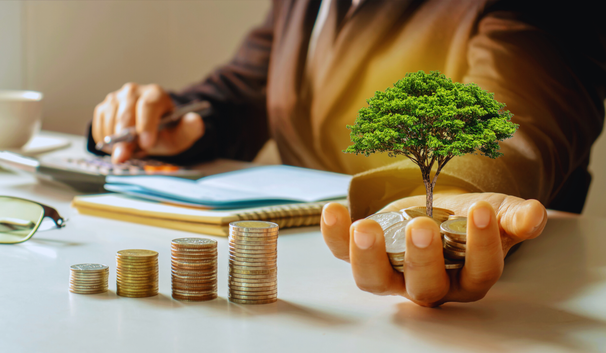 a man holding a tree in his hand representing investing