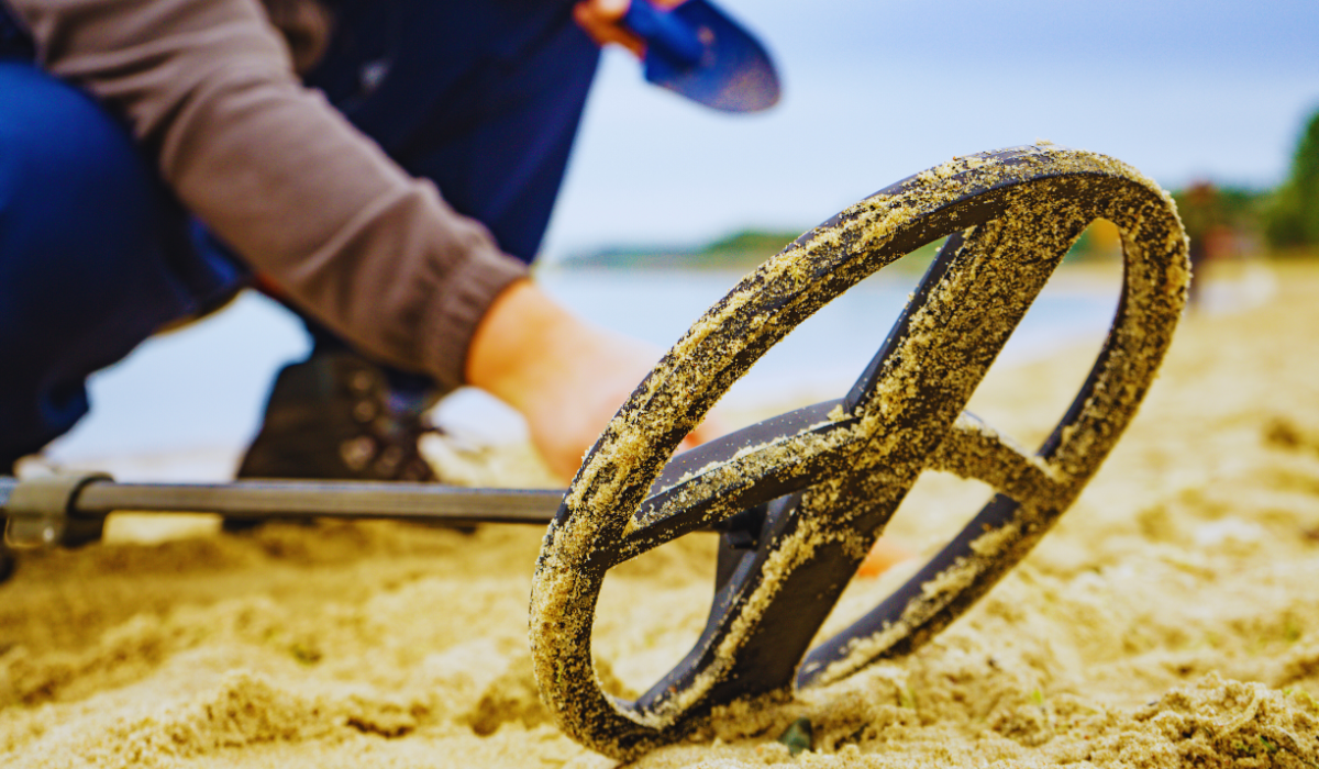 a metal detector laying in the sand