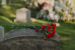 Read flowers resting on a gravestone